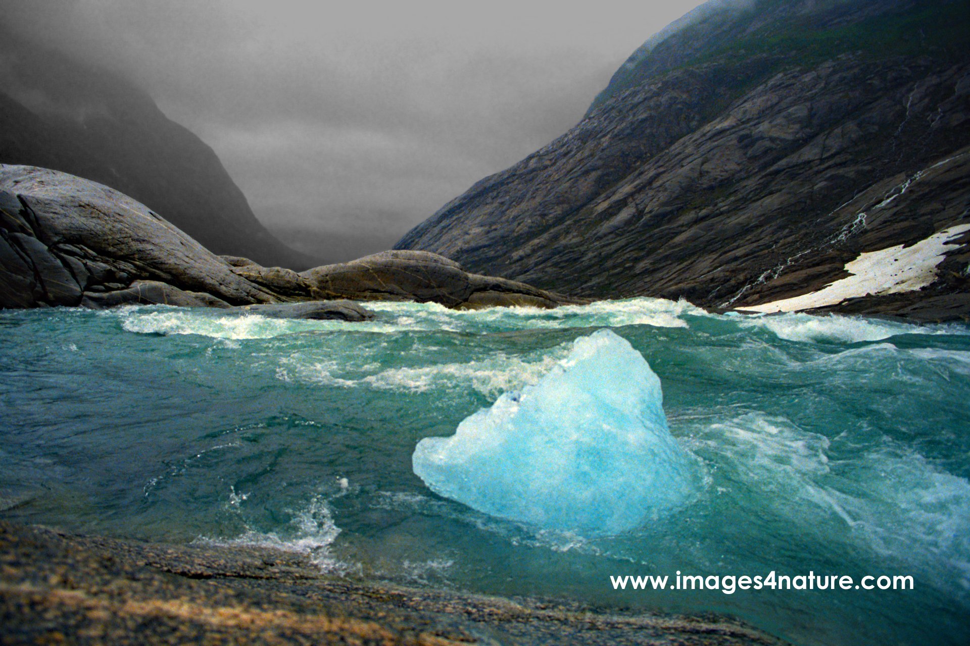 Bluish piece of ice swimming on the edge of Norwegian waterfall