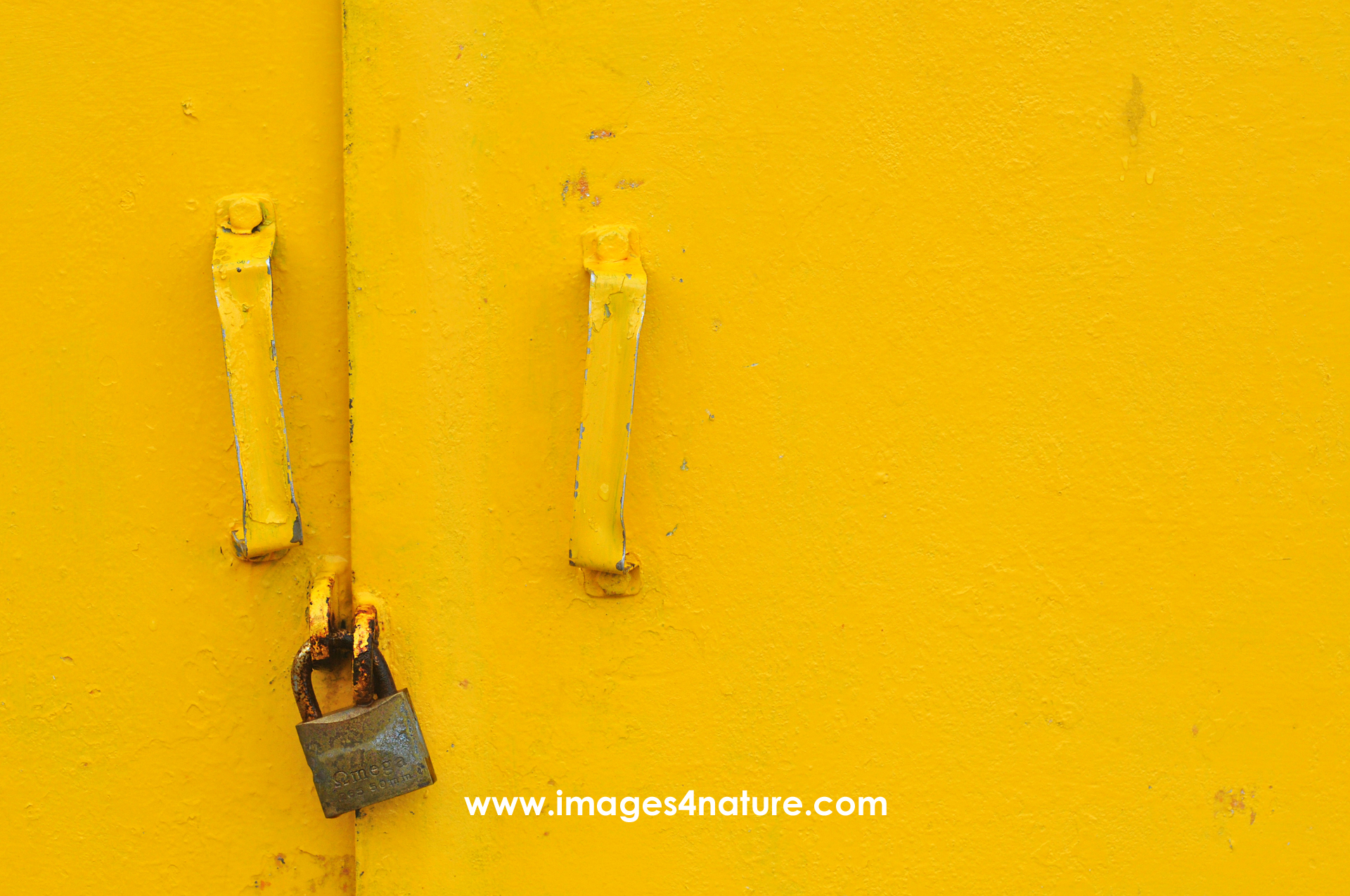 Close up on yellow doors with handles secured by padlock
