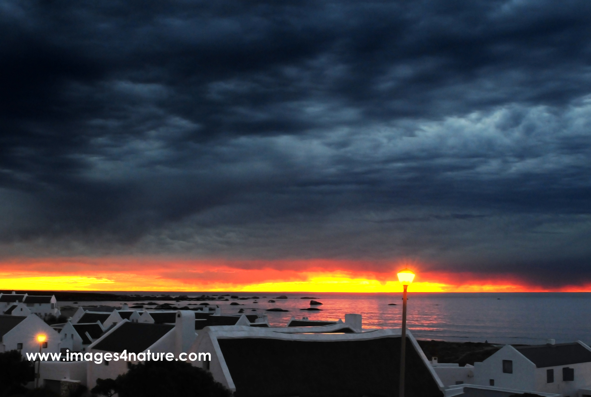 Dark storm clouds approaching Paternoster village at sunset