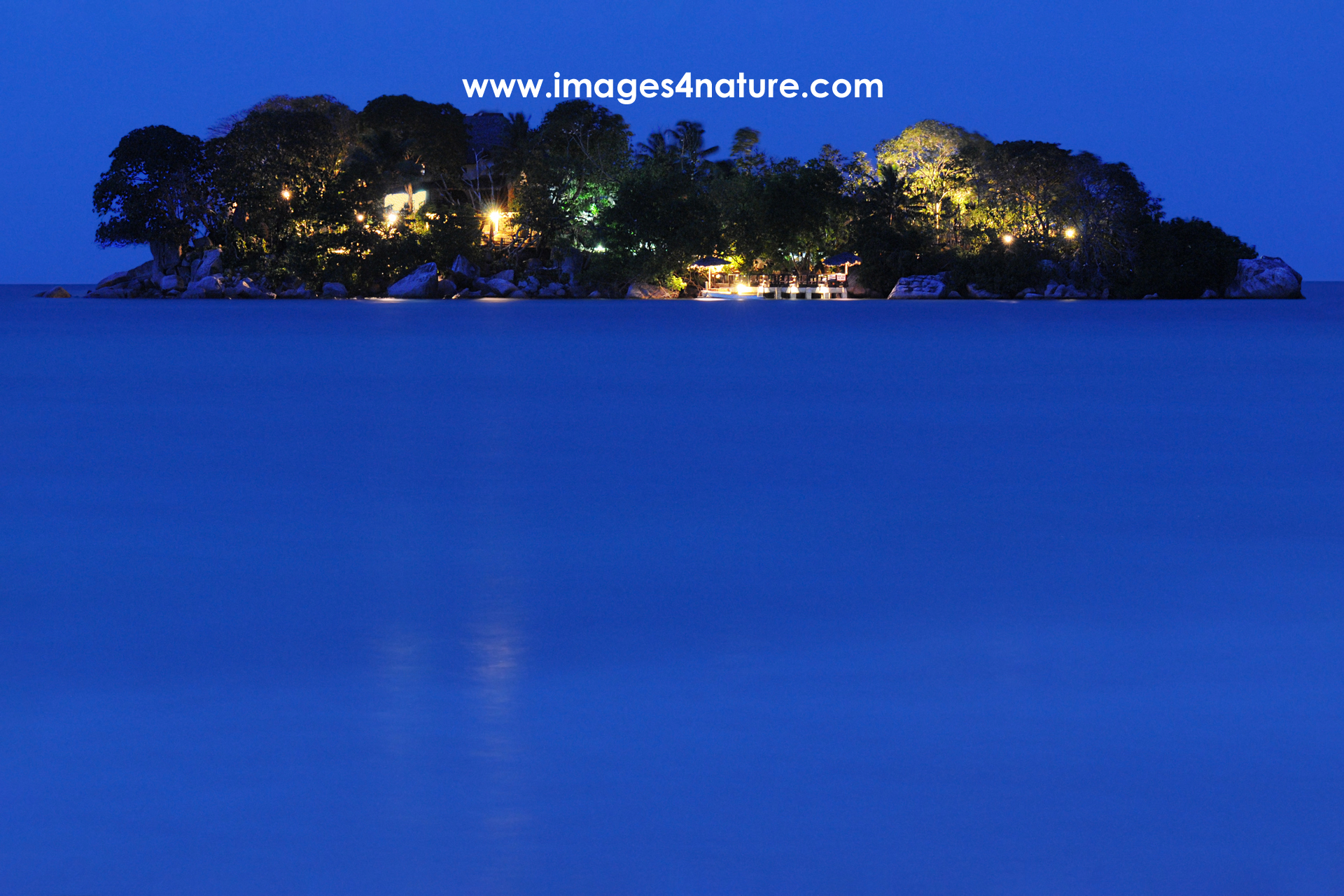Blue hour view of small touristic island with buildings and trees