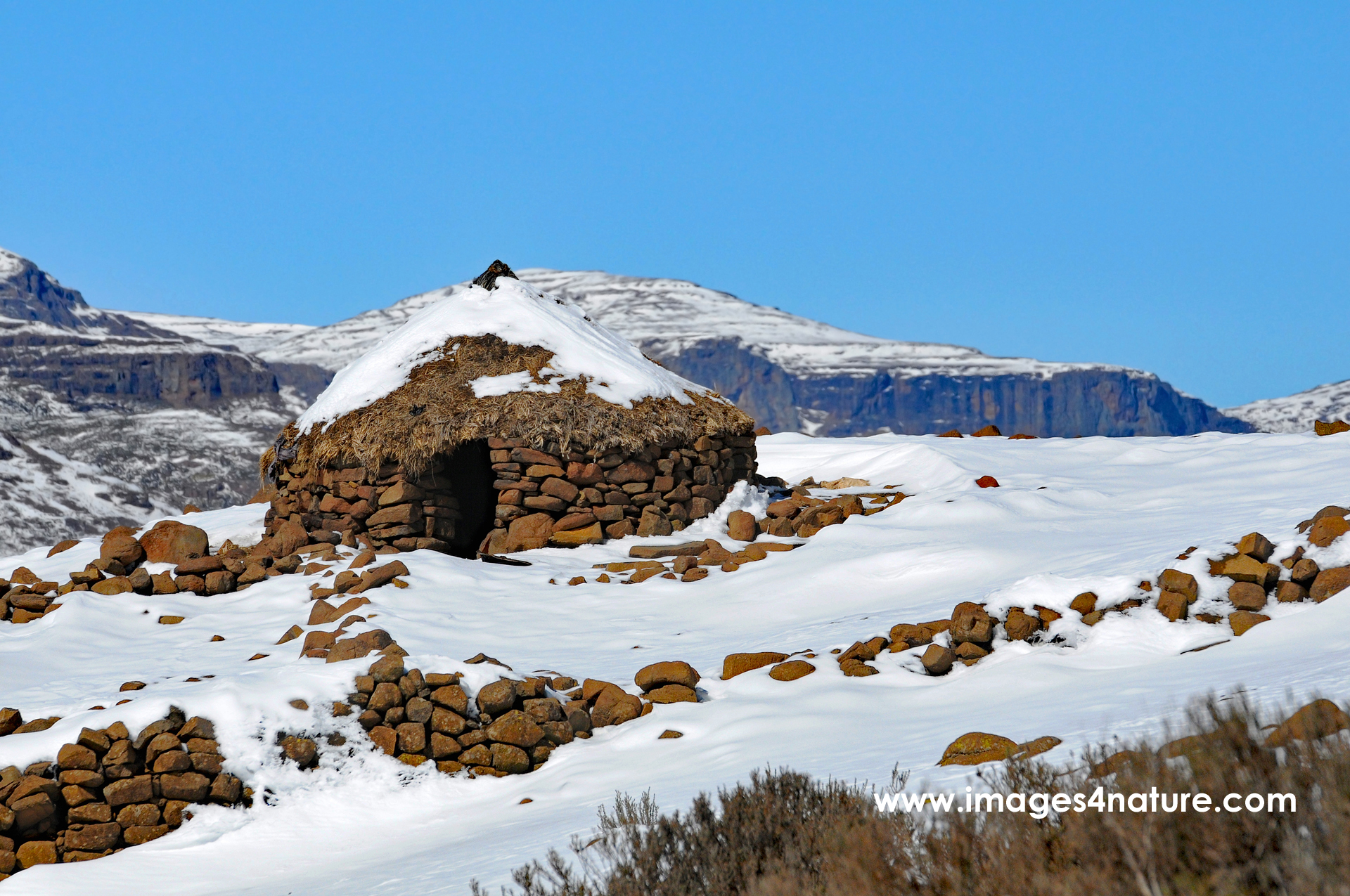 Typical Lesotho round stone house located in a remote snow covered mountain area