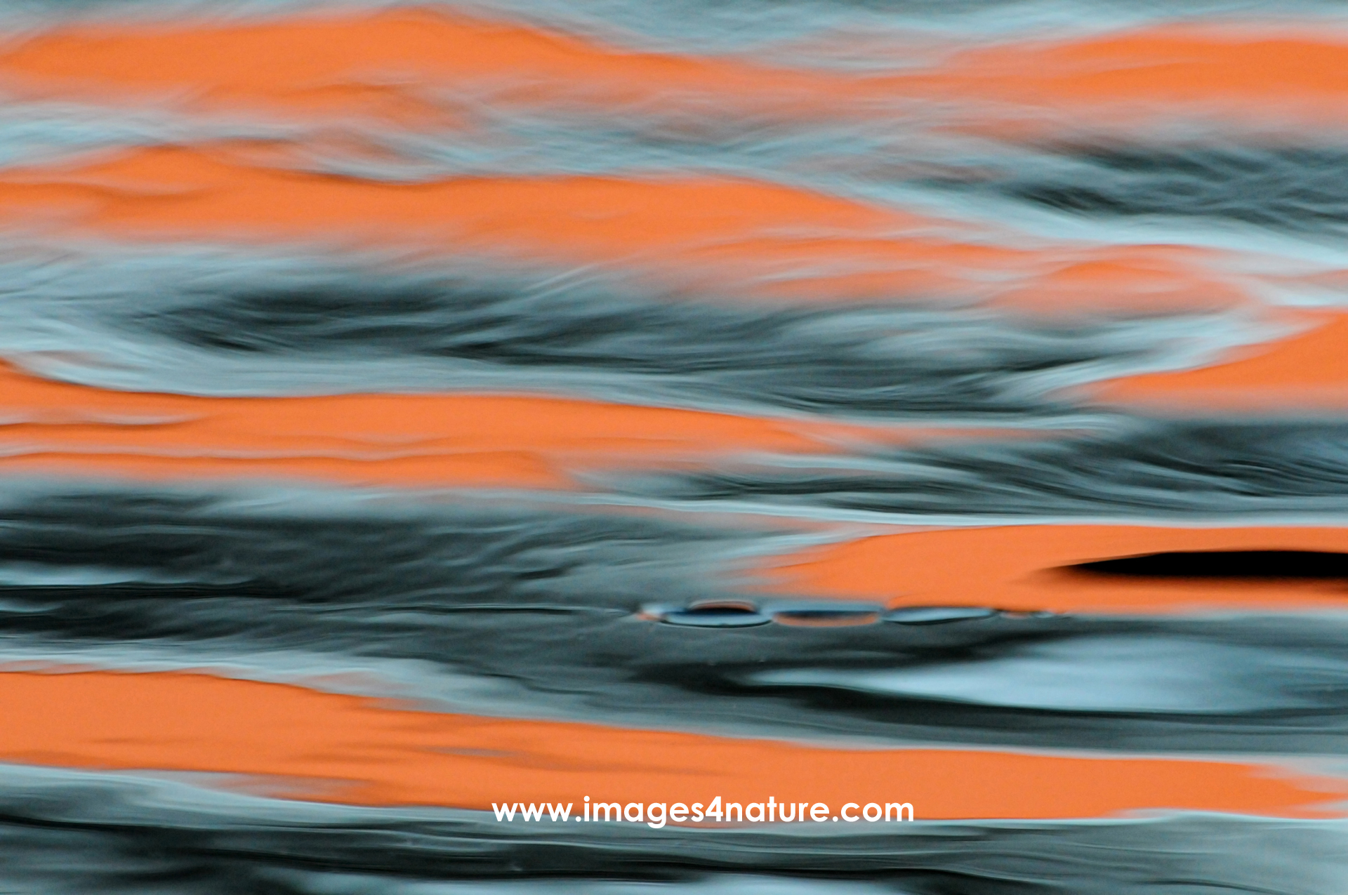 Abstract close-up on water surface with orange light reflections