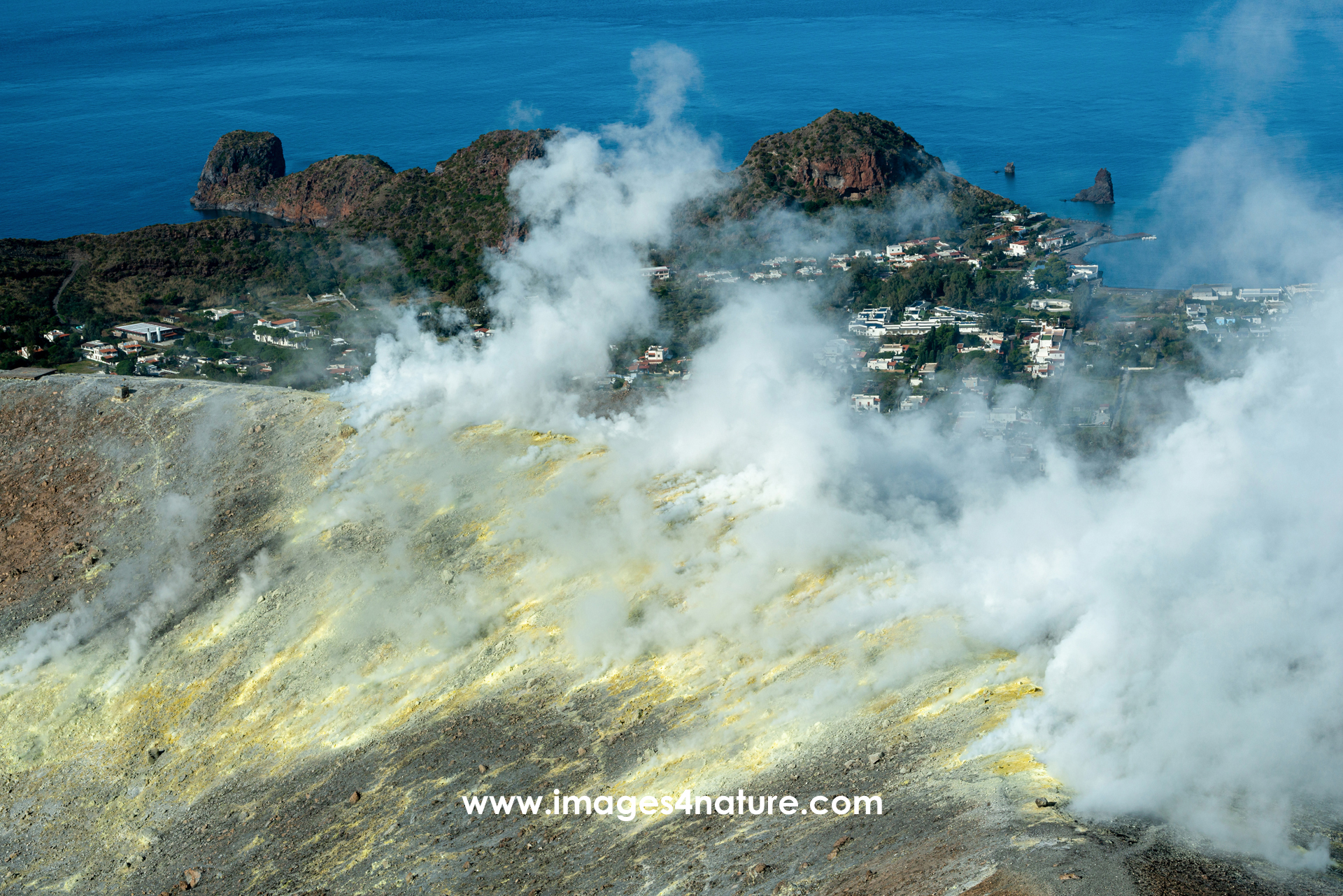 Italian island village behind smoking sulphor field fumeroles