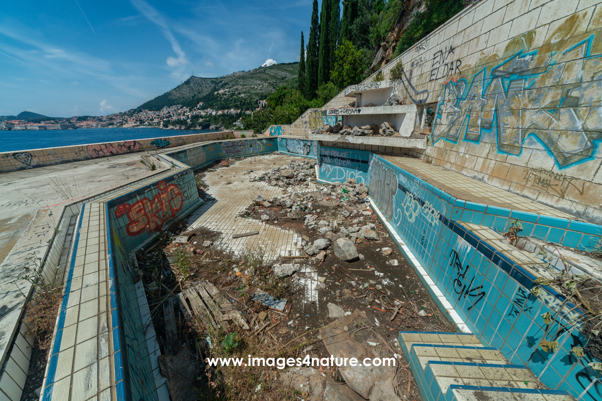 Empty outdoor swimming pool with graffitis at abandoned hotel