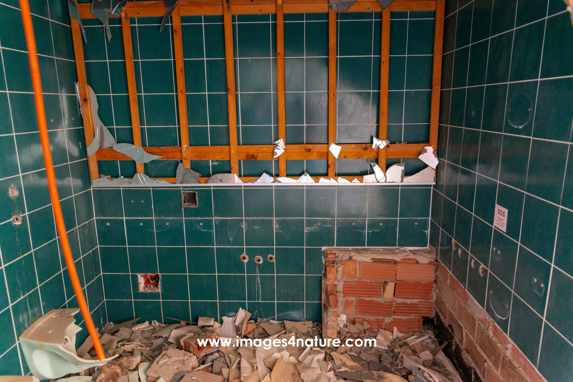 Dismantled bathroom with green tiles in abandoned hotel
