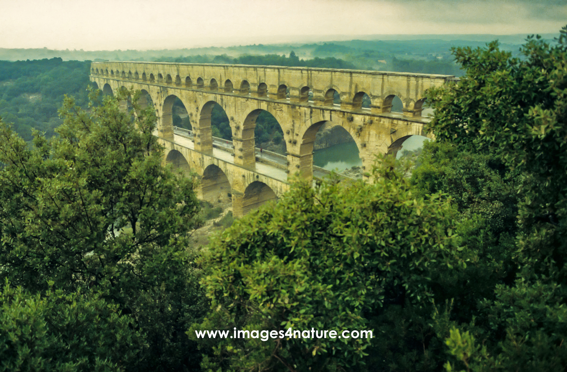 Side view of Pont du Gard aqueduct on a rainy summer day
