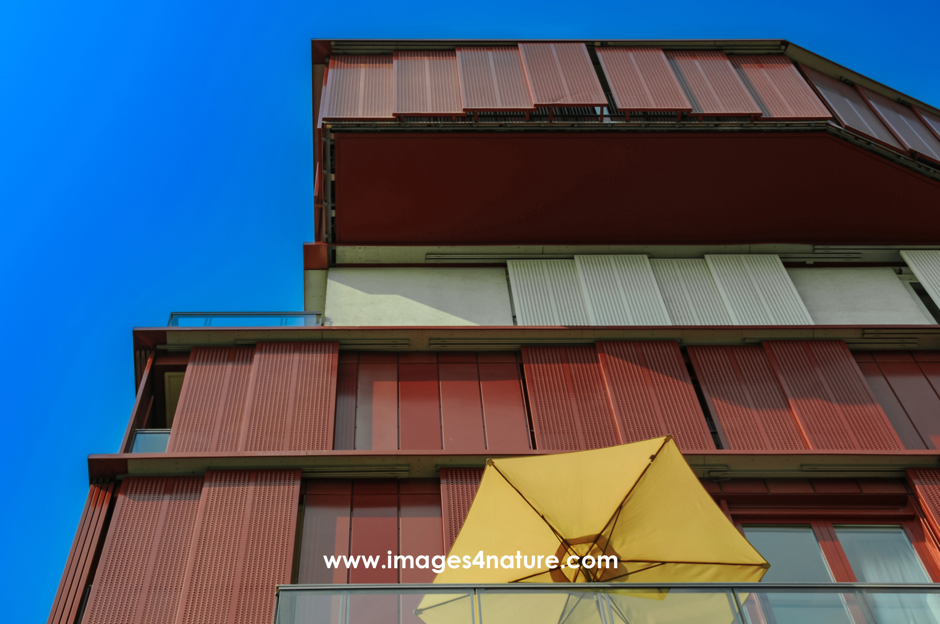 Low angle view of modern residential building with yellow sunshade