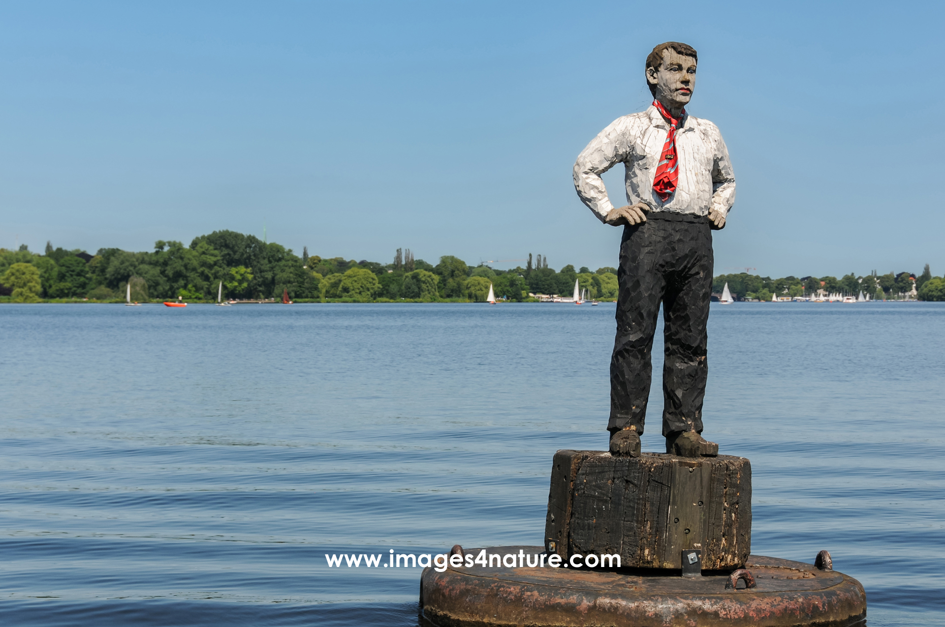 Wooden man sculpture on buoy within Outer Alster Lake