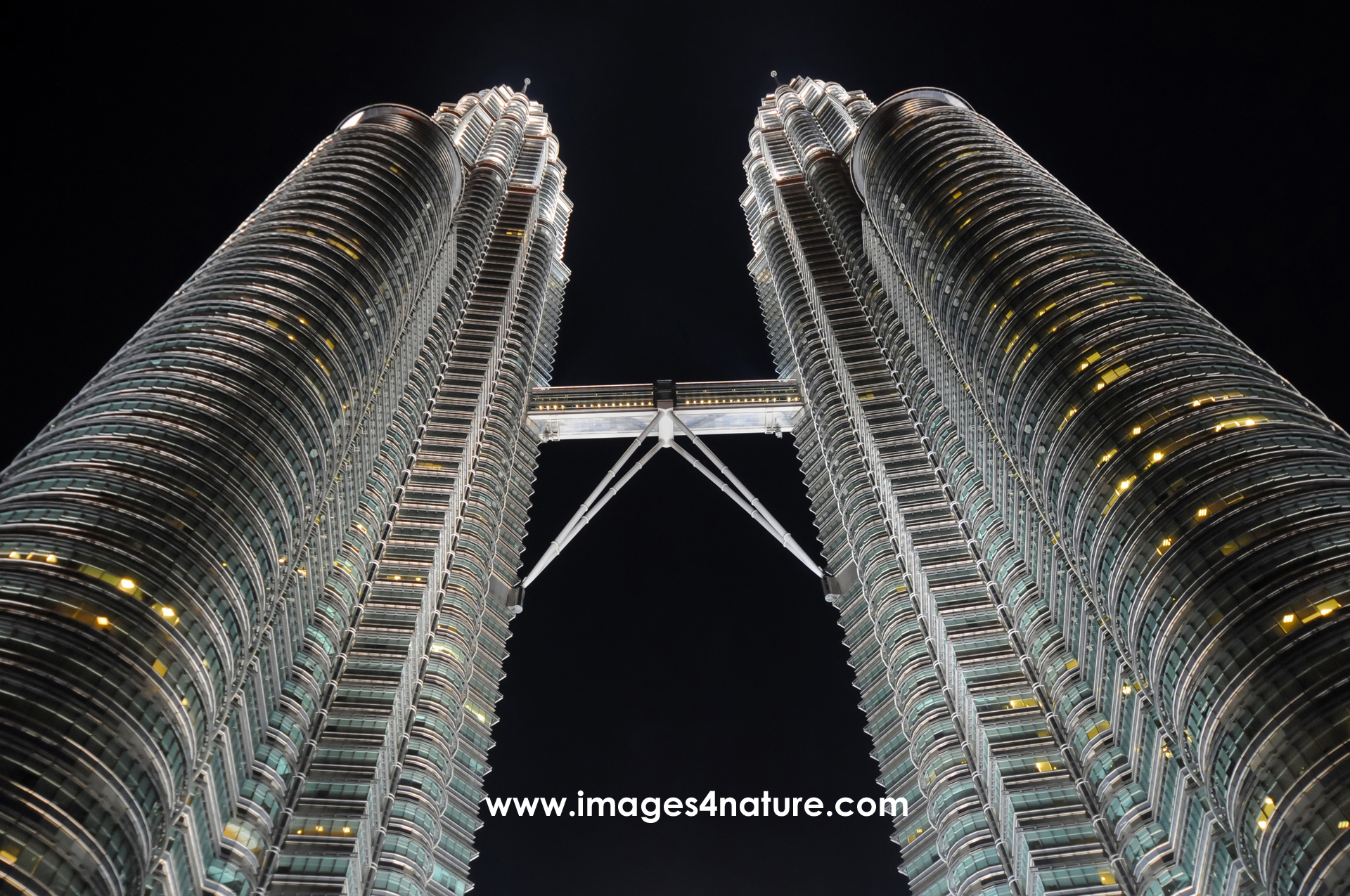 Low angle view of illuminated Petronas Twin Towers at night