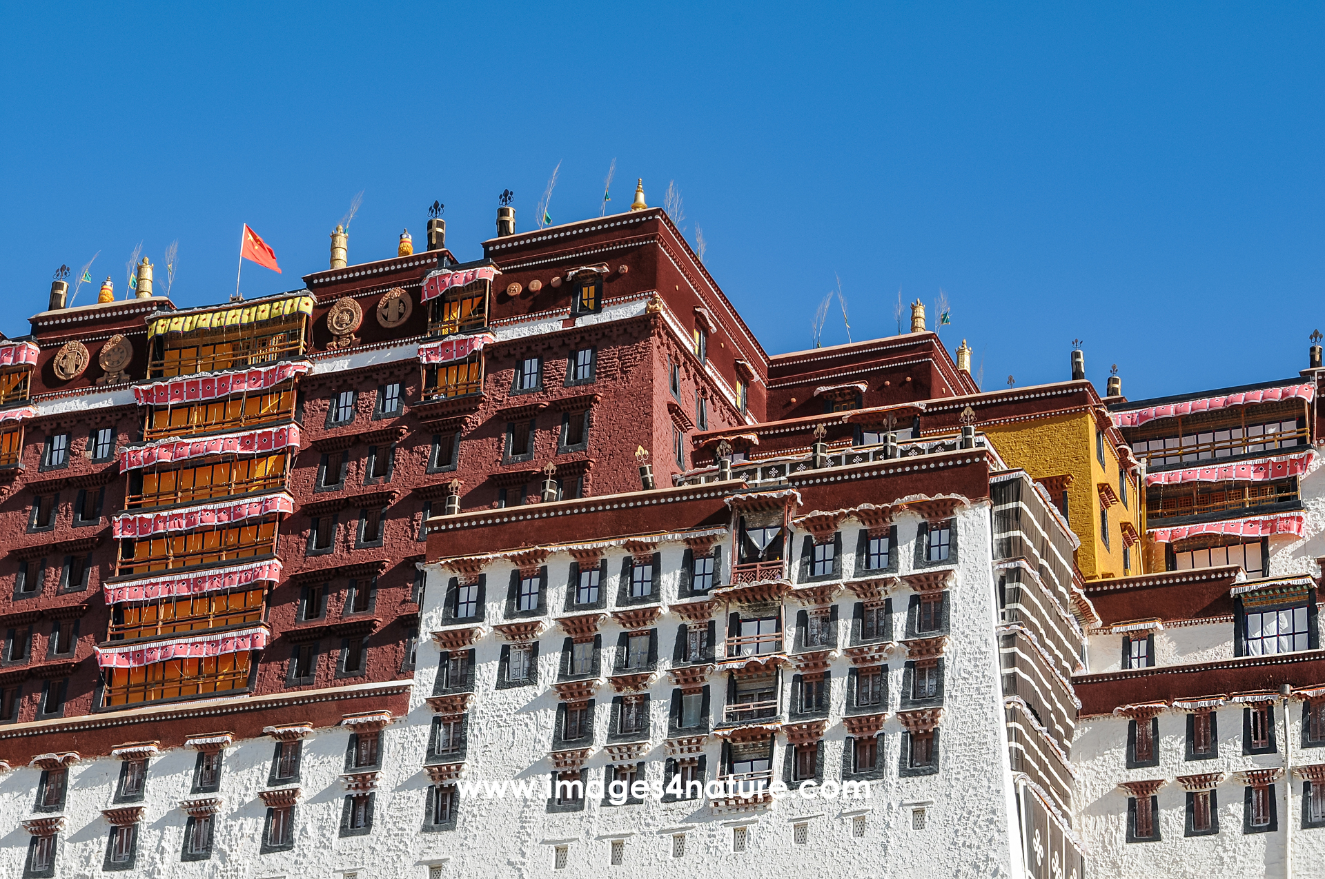 Partial view of the Potala Palace in Lhasa from low angle against blue sky