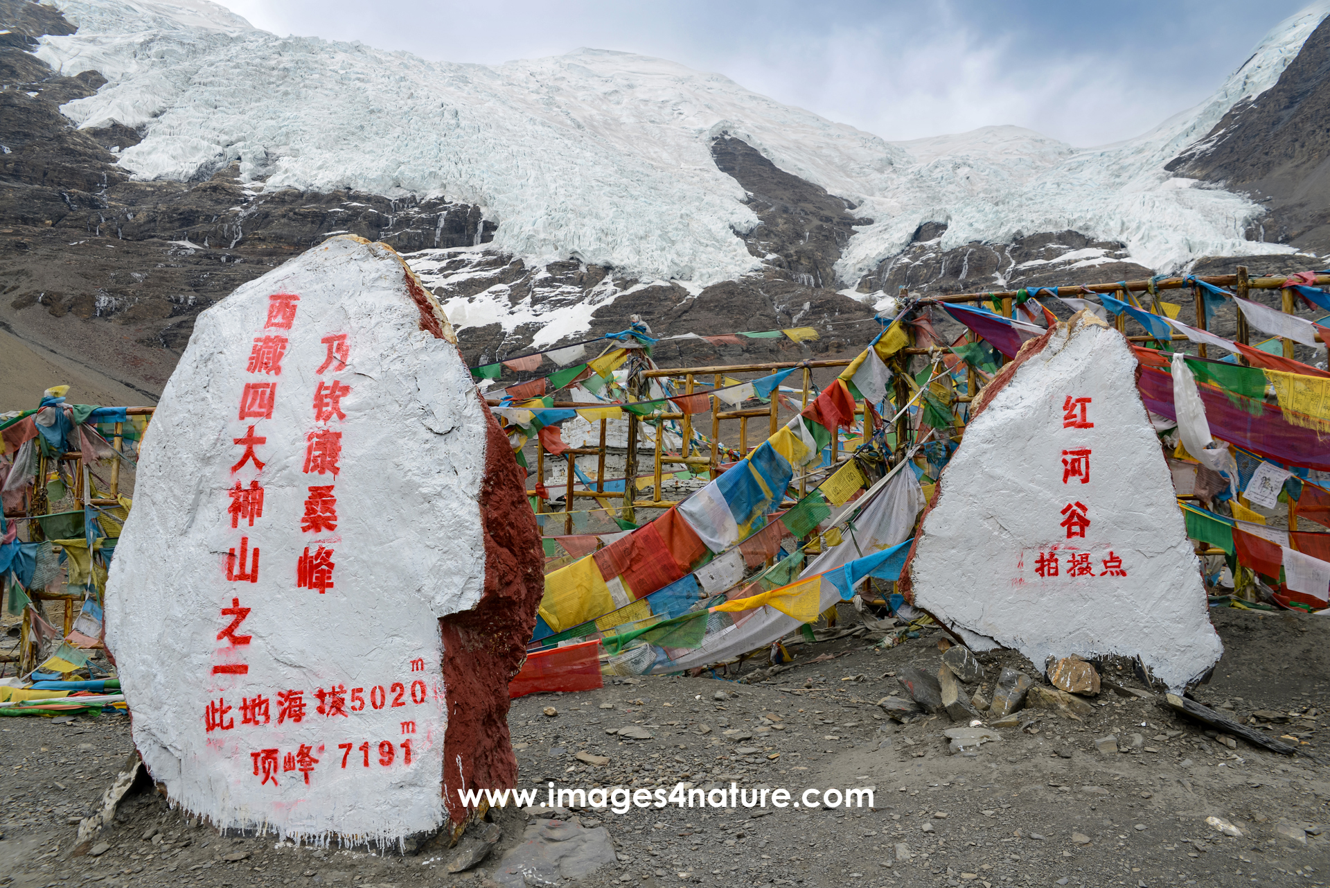 Two white painted stones with Chinese writing and altitude marker 5.020m at Kharola Glacier in Tibet