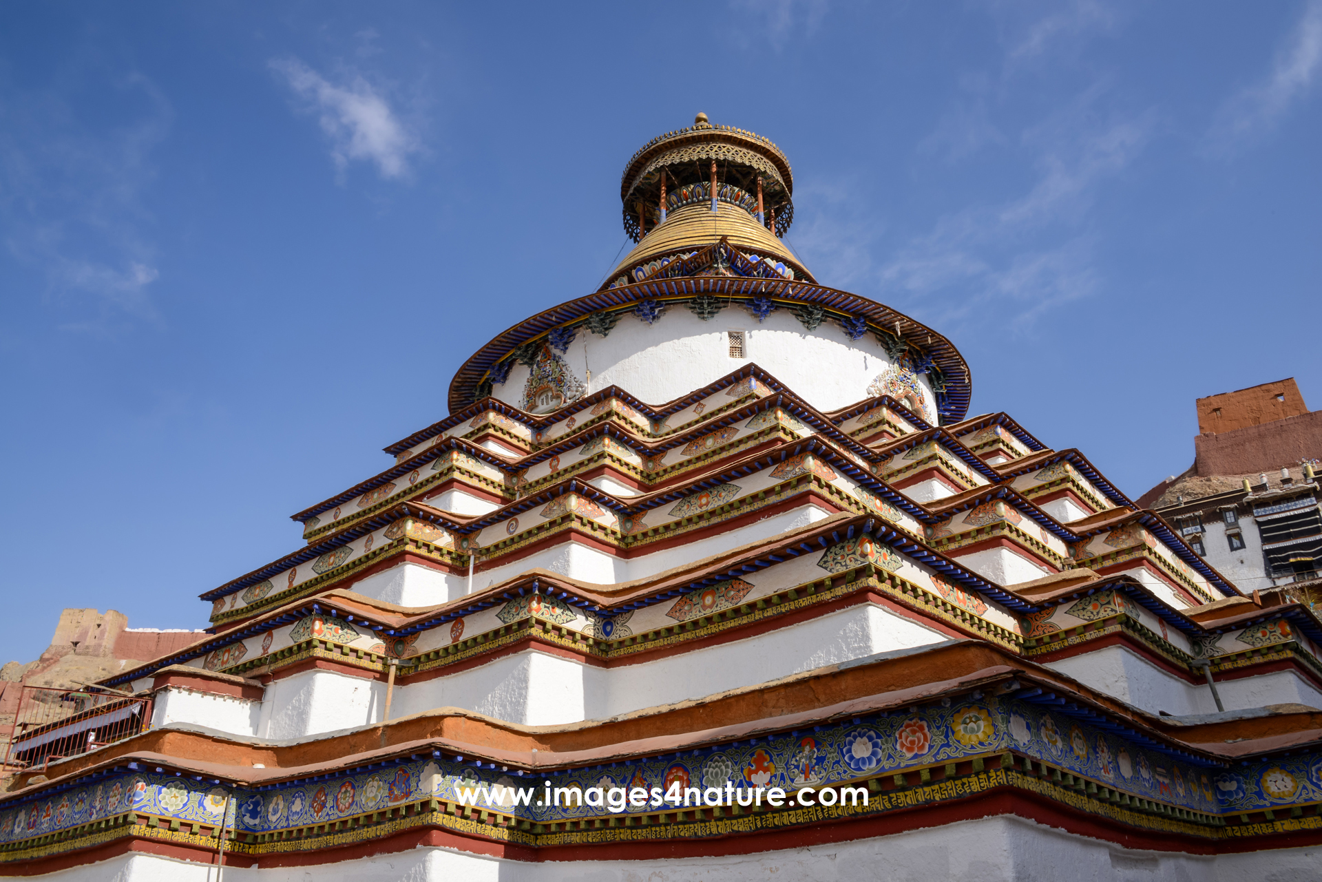 Low-angle view of the huge nine-floor high Kumbum at Palcho Monastery against blue sky