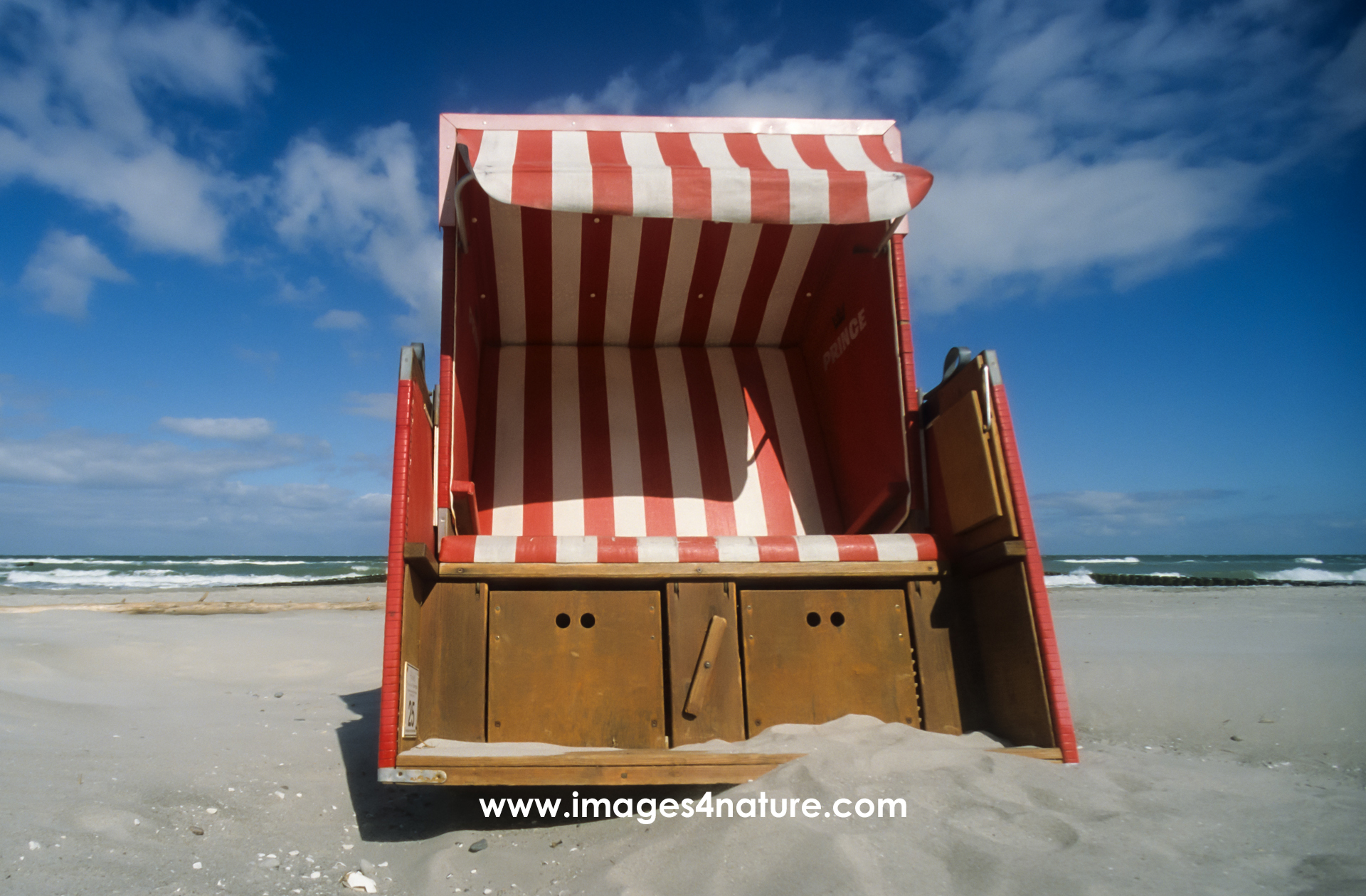 An empty basket beach chair for two people in the sand