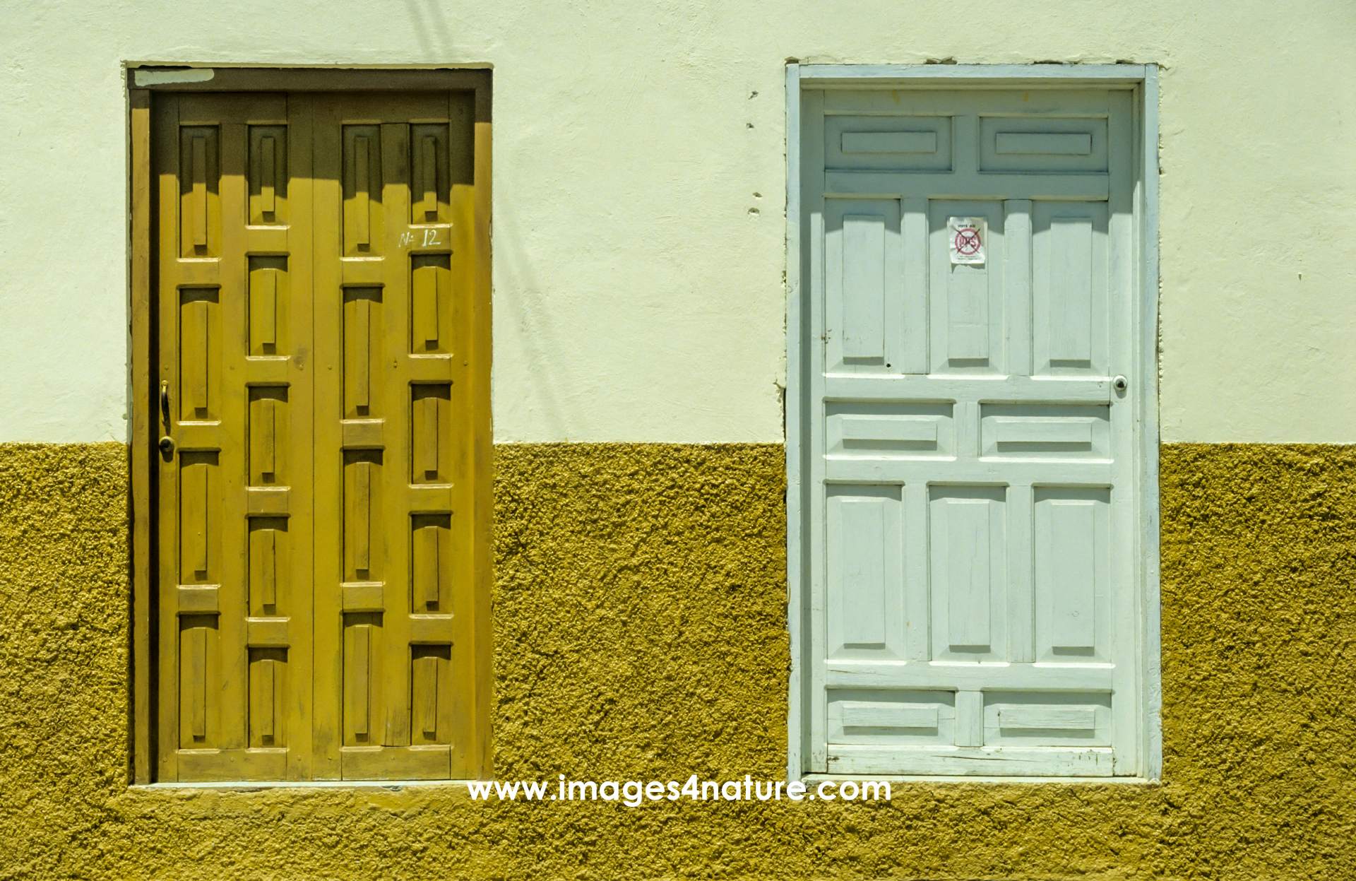 Two wooden doors with different patterns and colors in a textured wall