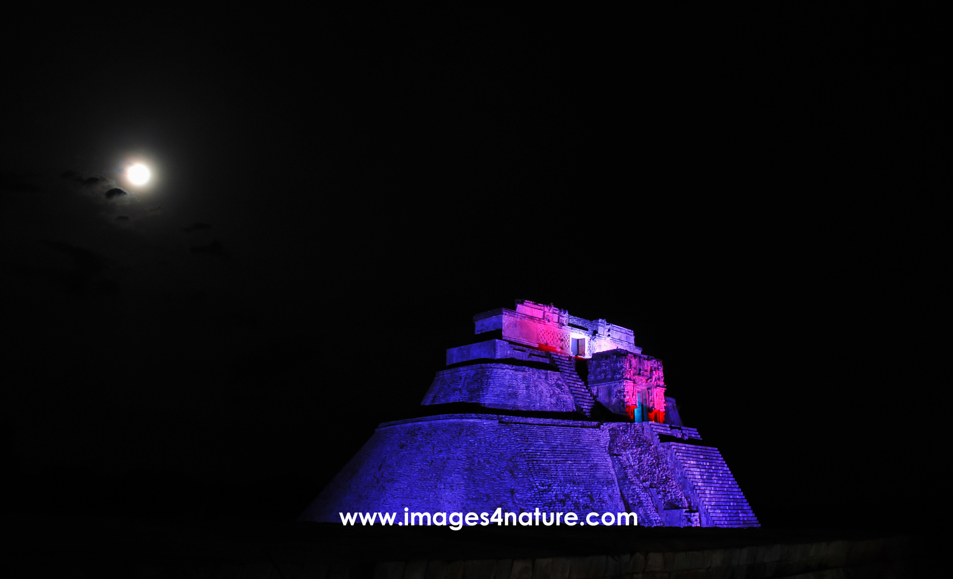 Night shot of one of the large pyramids of Uxmal illuminated by colored light