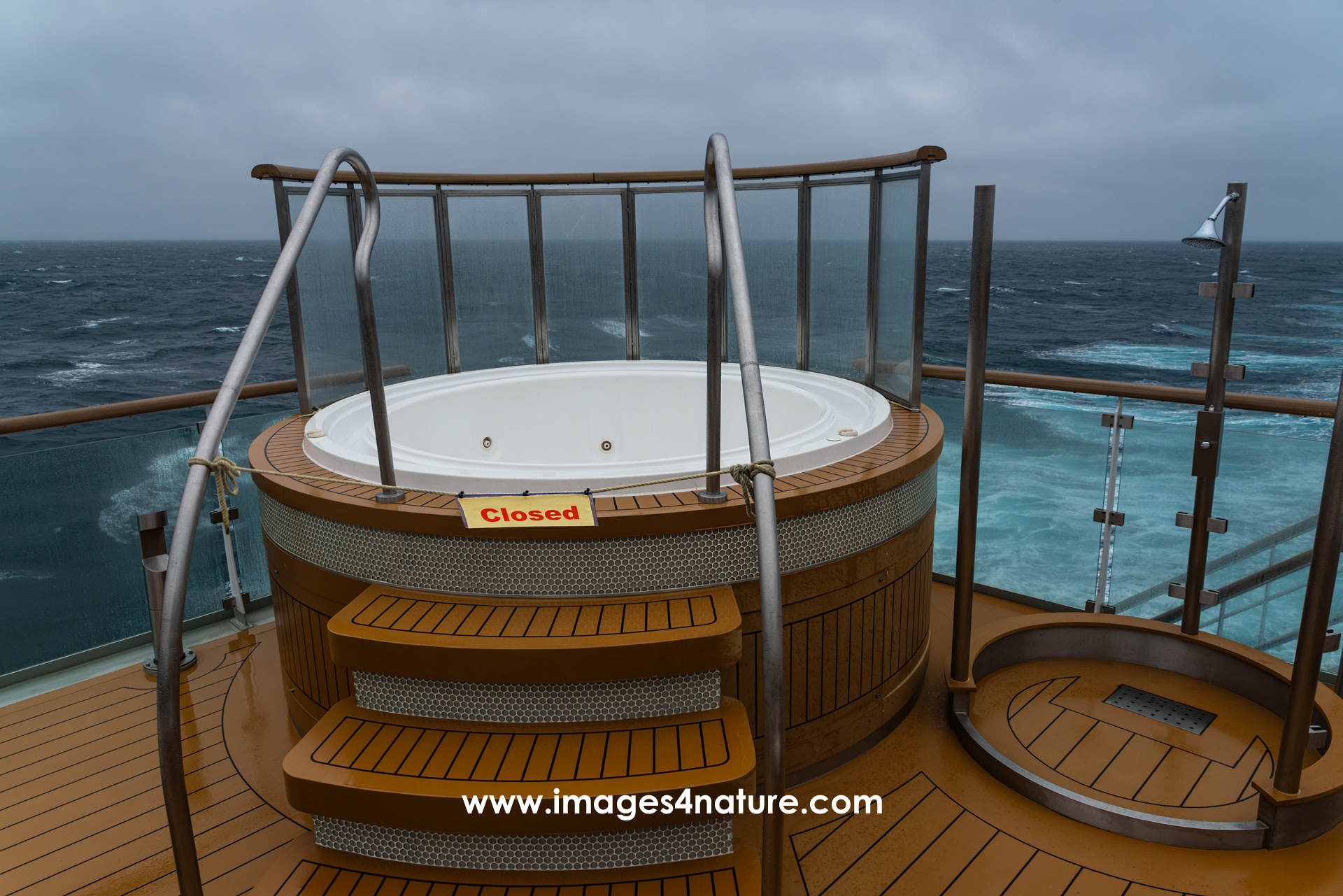 An empty whirlpool and shower on top of a cruise ship, closed due to bad weather