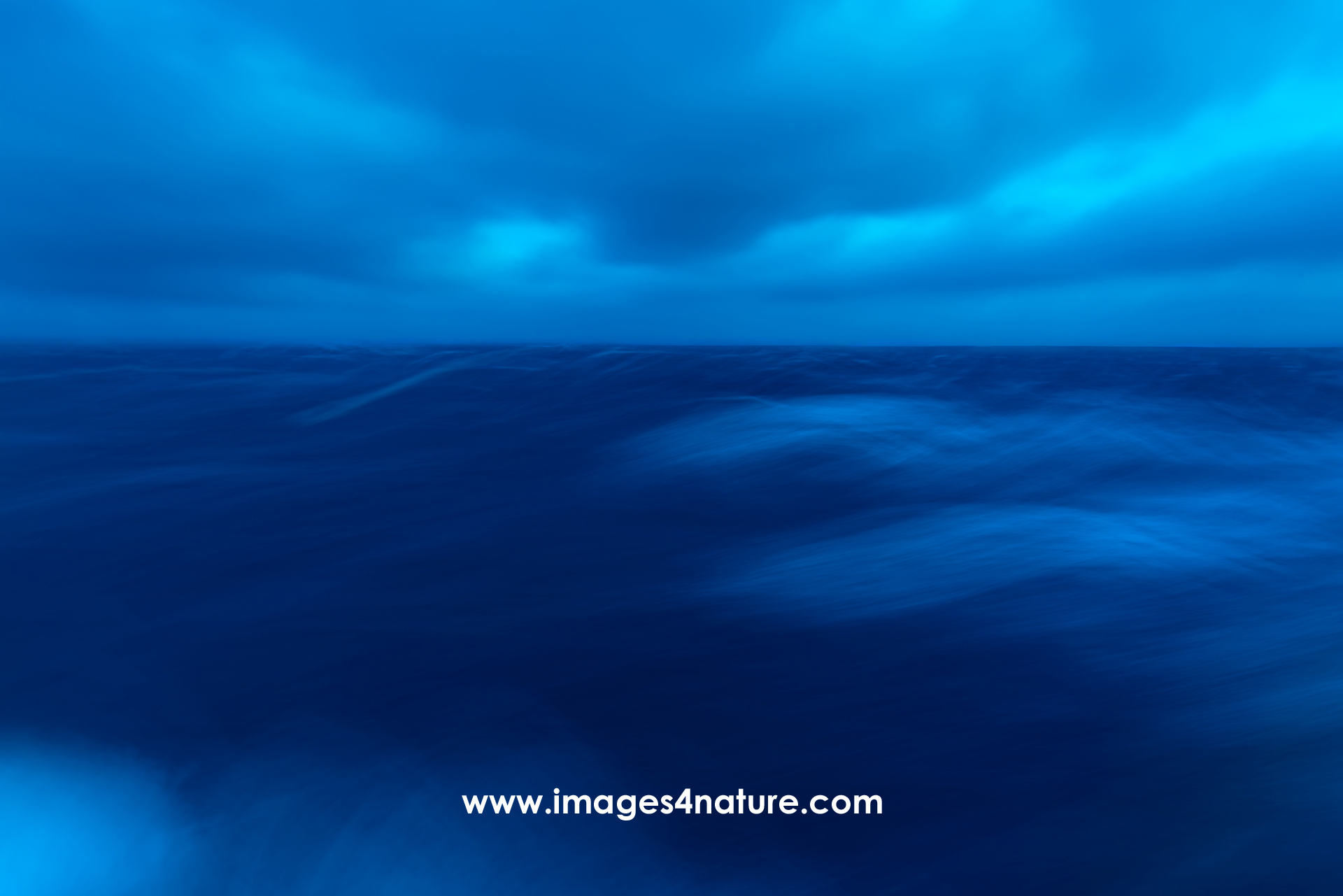 Long exposure blue hour shot of ocean waves during a strong storm